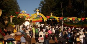bildet viser mange festkledde ortodokse personer foran en ortodoks kirke