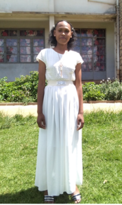 Bildet viser ei jente i hvite klær på konfirmasjonsdagen