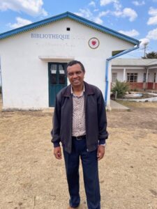 Bildet viser bibleskolens rektor Andriamparany Jean Christian foran biblioteket
