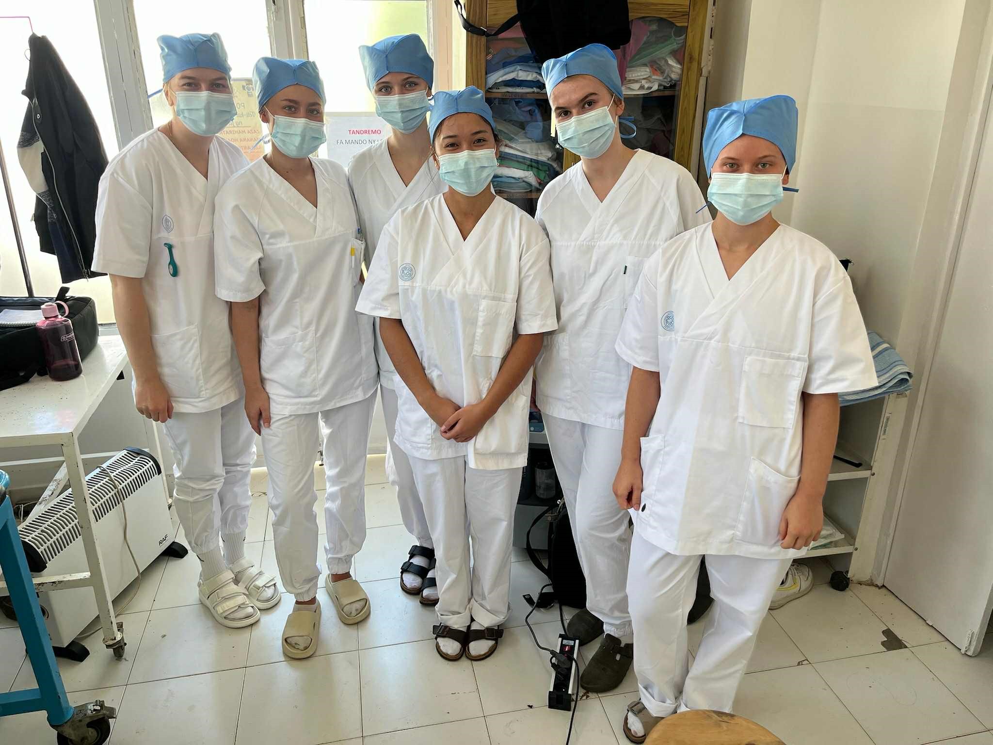 Bildet viser 6 studenter med munnbind, arbeidsklær og hodeplagg